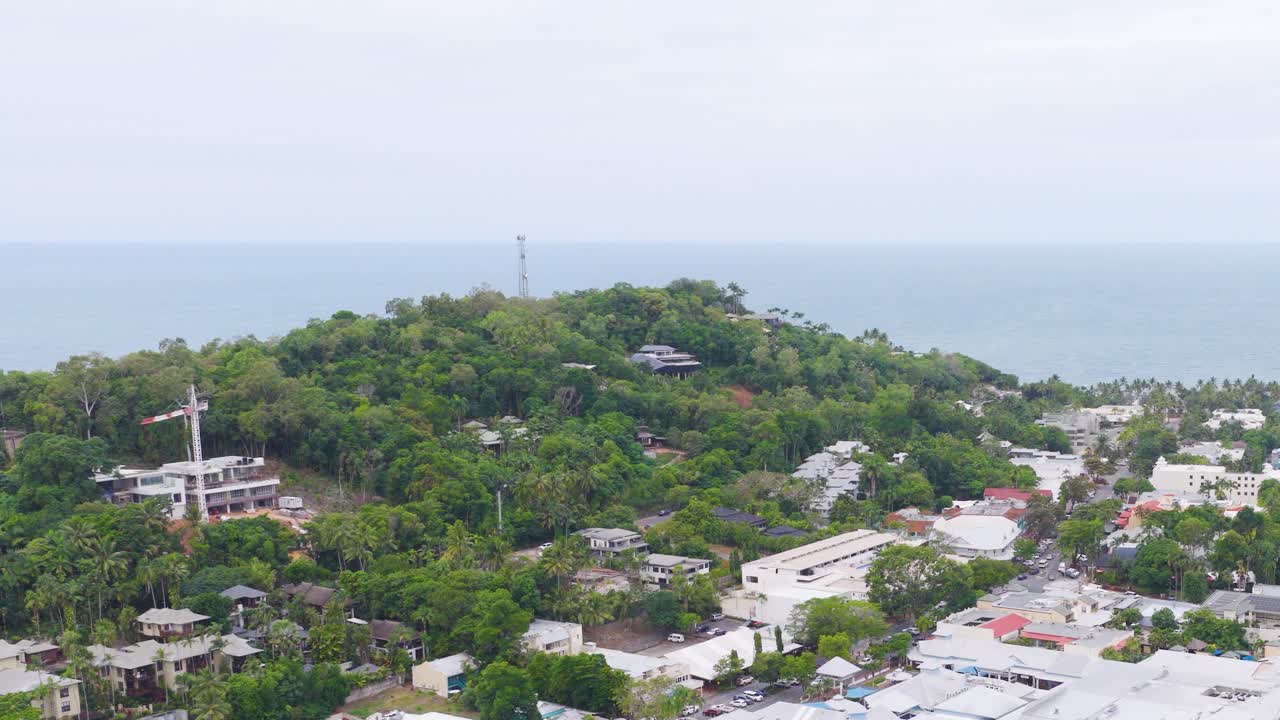 Aerial footage captures lush greenery and coastal scenery in Port Douglas, Australia, under soft daylight with a serene atmosphere