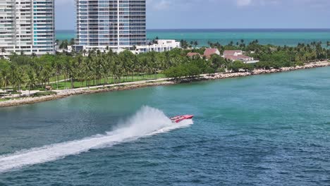 Aerial-tracking-shot-of-speedboat-cruising-in-Miami-Beach-with-palm-trees