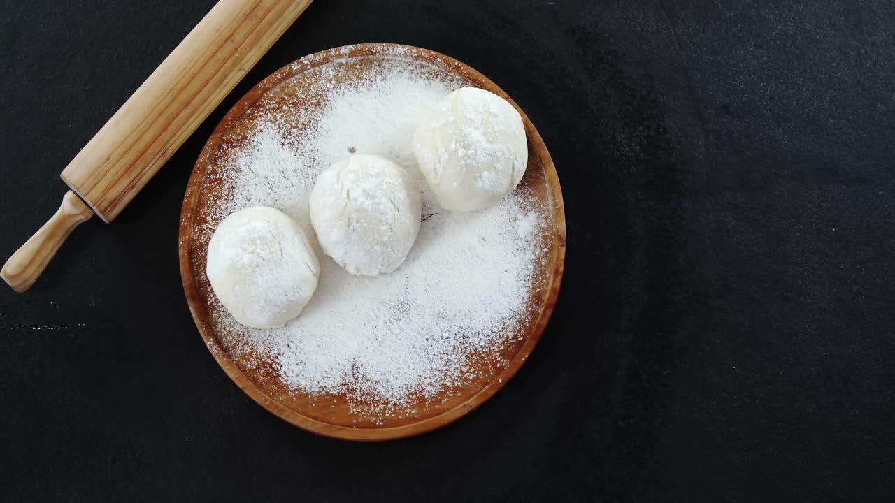 rodillo con masa de pizza y harina en el plato