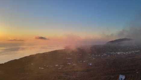 salida del sol aérea panorámica en las nubes en la isla de santorini, grecia