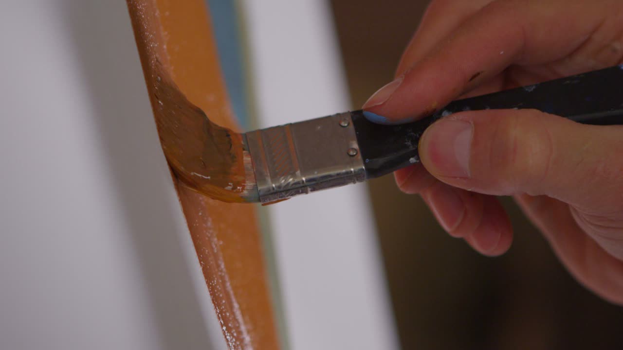 primer plano de un artista embadurnando pintura sobre un lienzo