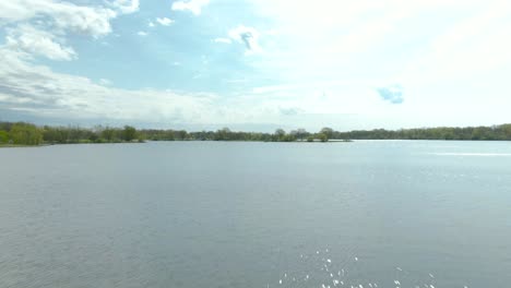 A-fast-moving-shot-with-a-vertical-panning-motion-over-water-in-a-small-suburban-national-park-lake-in-the-western-suburbs-of-Chicago,-Illinois-near-Lemont,-IL