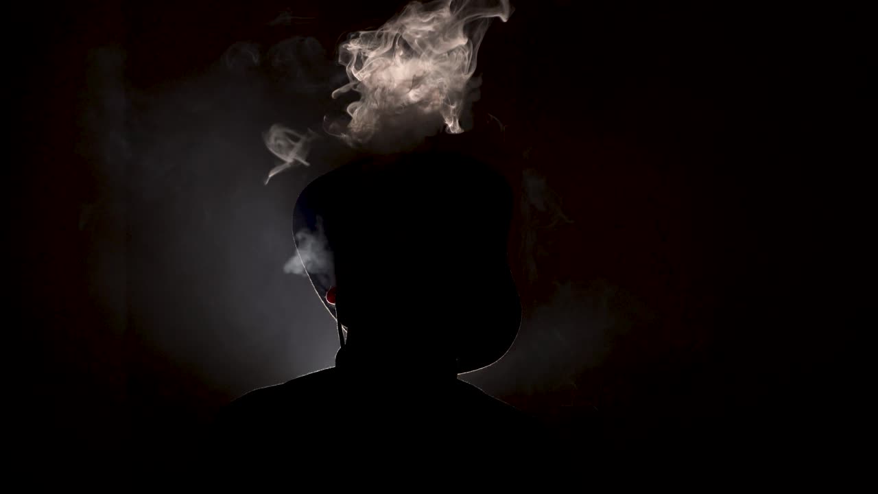 Mysterious Silhouette of a Man in a Hat with Smoke