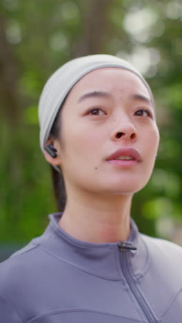 vertical video close up of young woman zipping up sportswear top before exercising running along urban street