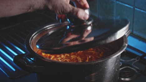 placing stainless steel lid in venting position on top of soup in silver pot