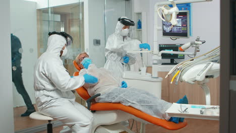 dental specialist with coverall talking with patient before examination