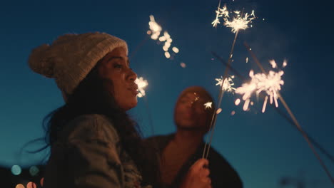 Fröhliche-Freunde-Halten-Wunderkerzen-In-Der-Hand-Und-Feiern-Silvester-Auf-Dem-Dach-Bei-Sonnenuntergang-Und-Haben-Spaß-Daran,-Die-Feiertagsfeier-Zu-Genießen