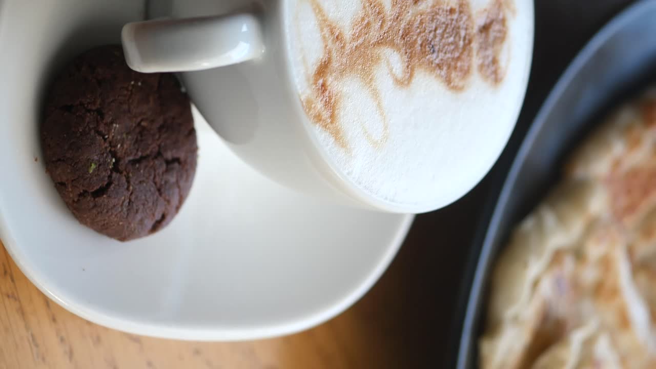 Coffee with Latte Art and a Cookie