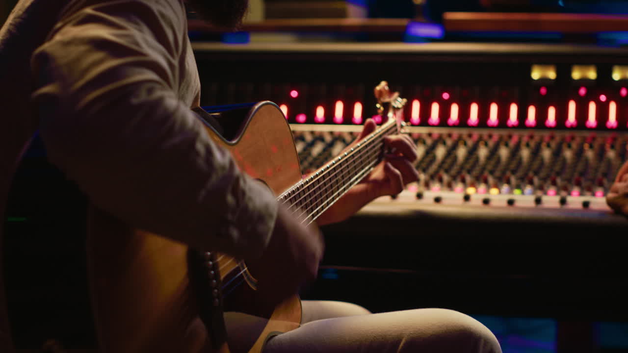 작곡가가 전문적인 스튜디오에서 사운드 엔지니어와 함께 곡을 작곡하고 있습니다.