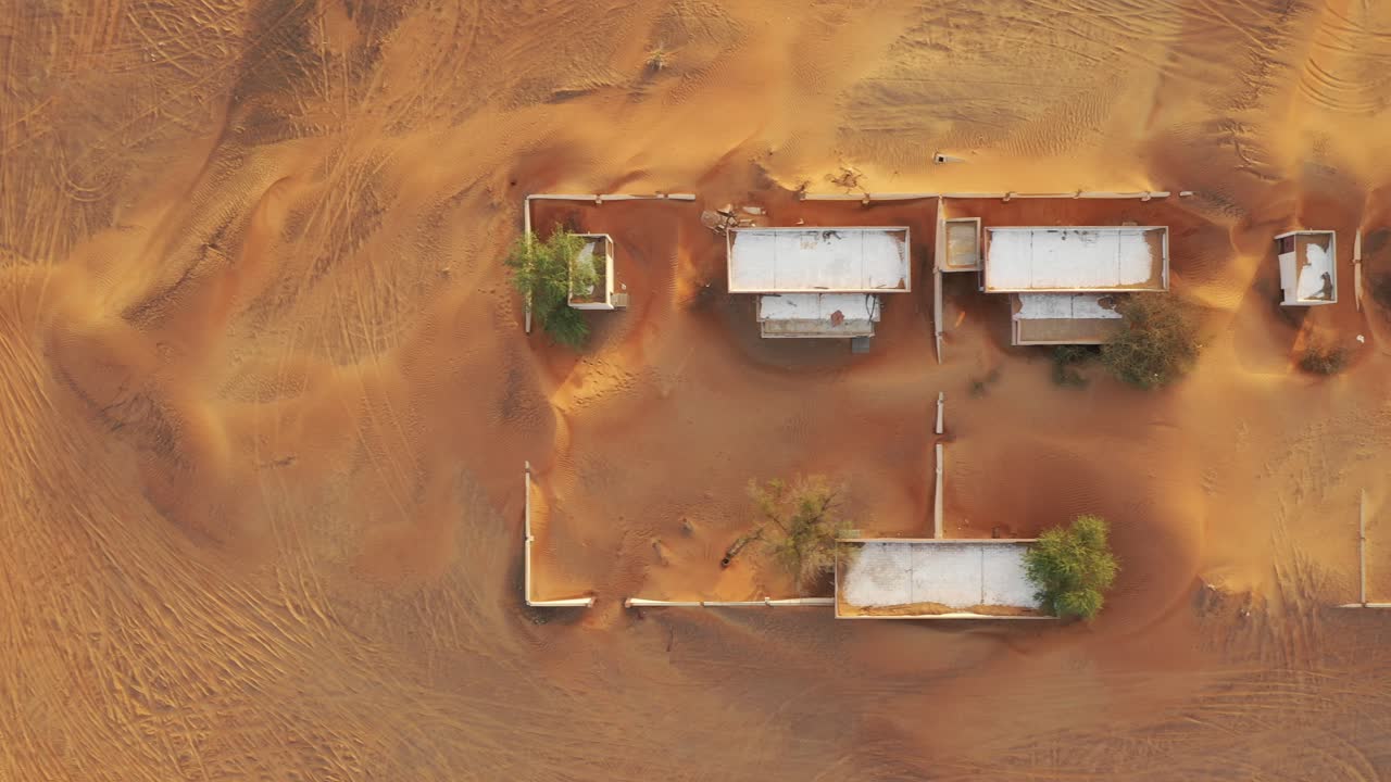 두바이 근처의 사막 모래로 뒤덮인 텅 빈 버려진 마을과 집의 공중 전망