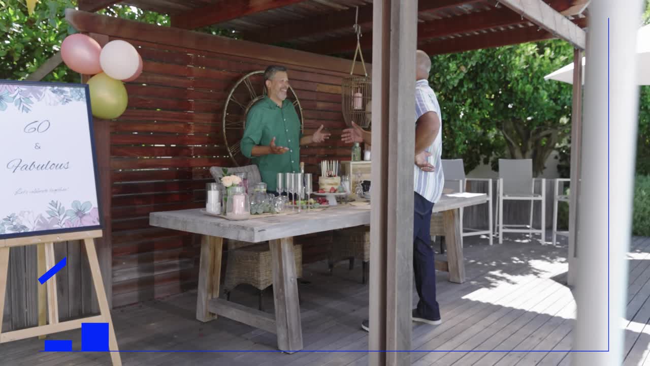 Two men arranging 60th party table on deck, striped man leaning, blue graphic growing over table