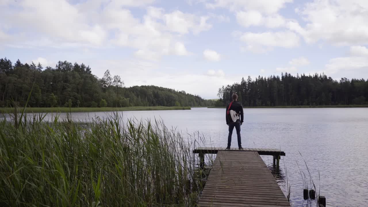 Man with Guitar on a Lake Dock