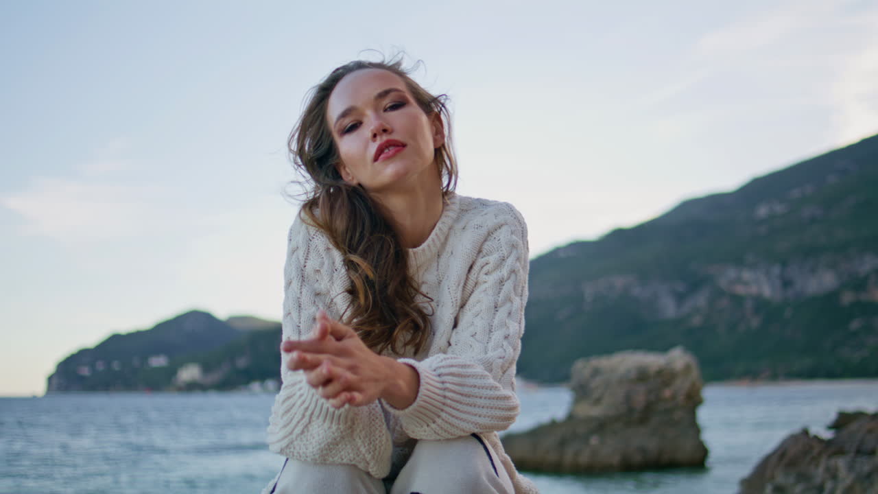 Calm tourist posing ocean coastal rocks at twilight closeup. Model relaxing