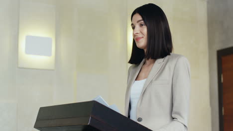 정장을 입고 회의실에서 이야기하는 연단에 있는 백인 여성 사업가의 클로즈업 보기