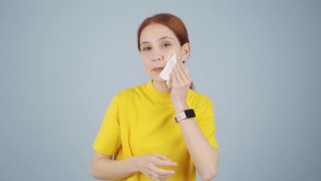 a woman trying to remove her make-up.