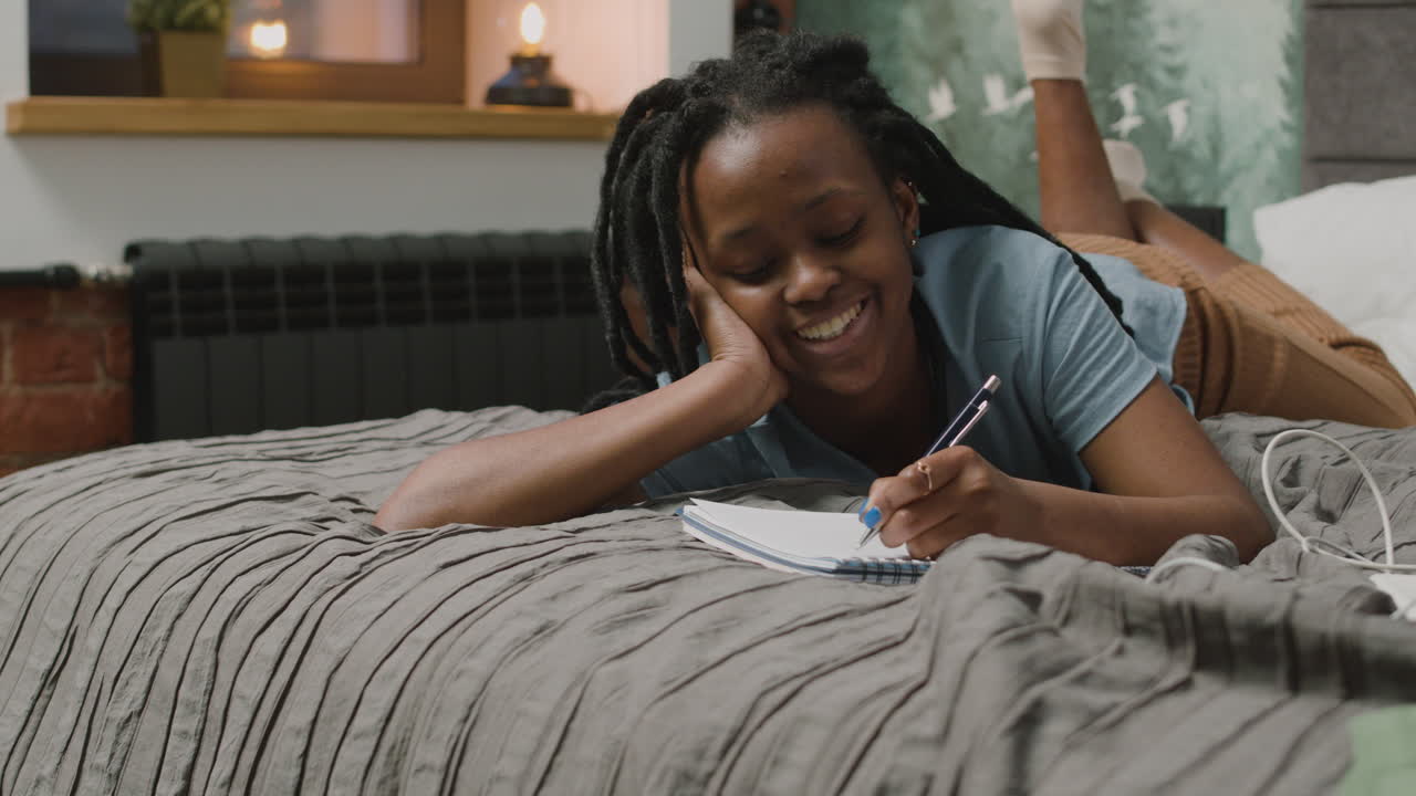 Girl Are Taking Notes Lying On The Bed In Bedroom