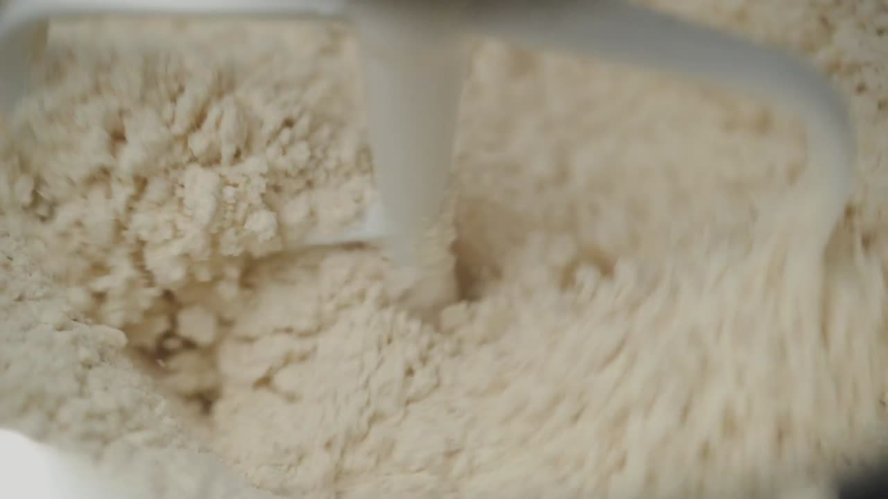 Mixing dough using a kitchen machine slow motion close up