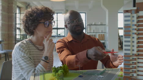 architects discussing building model in office