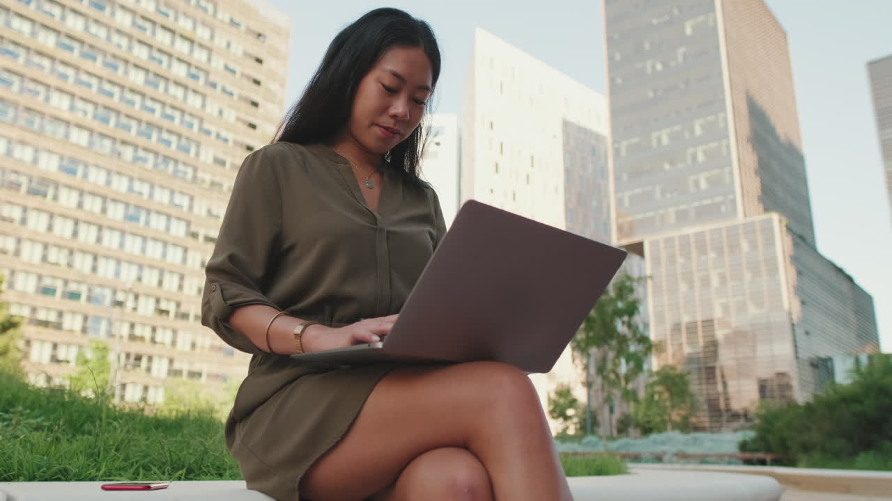 Woman working on laptop in city