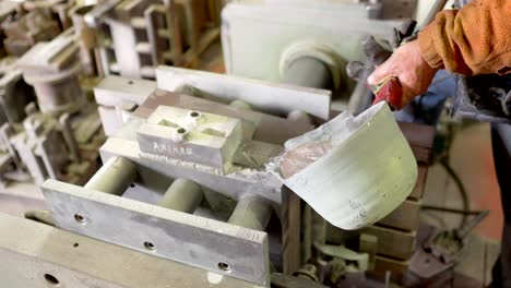 mold aluminum casting pouring by hand from male worker