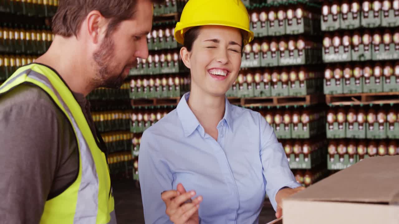supervisoras riendo mientras escriben en el clipboard en el almacén