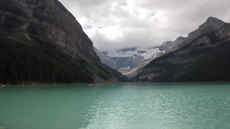 Time-lapse-of-Lake-Louise,-with-canoes-drifting,-clouds,-and-sunlight