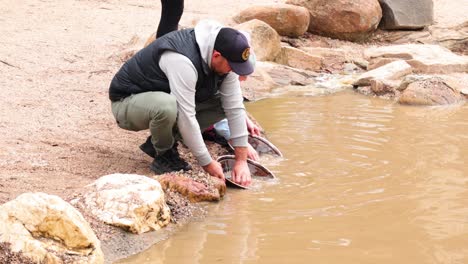 man panning for gold in muddy water