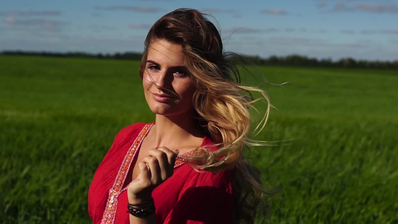 женщина в красном платье в зеленом поле