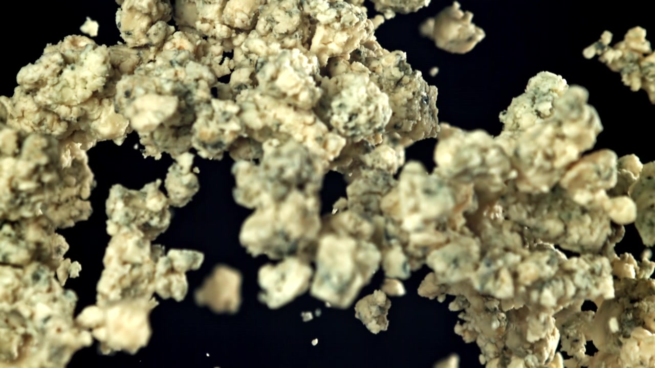 Briciole di formaggio erborinato che cadono in super rallentatore