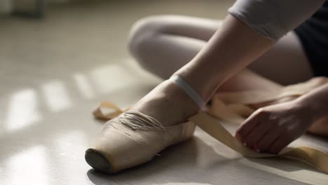 ballerina tying pointe shoes