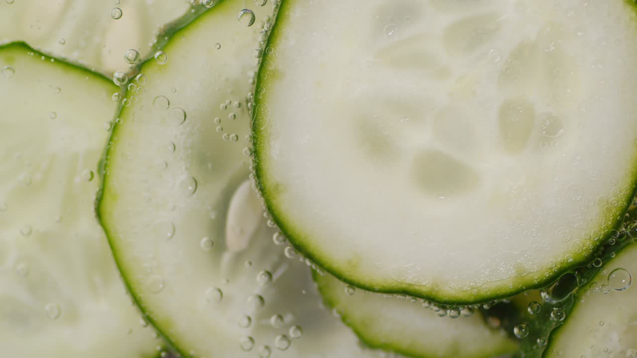 rebanadas redondas de pepino fresco bajo agua con burbujas de aire.