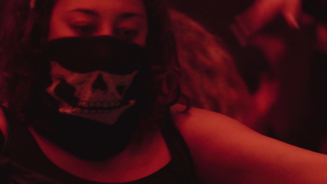 Young woman with face mask dancing at a night club event. Festivals post pandemic