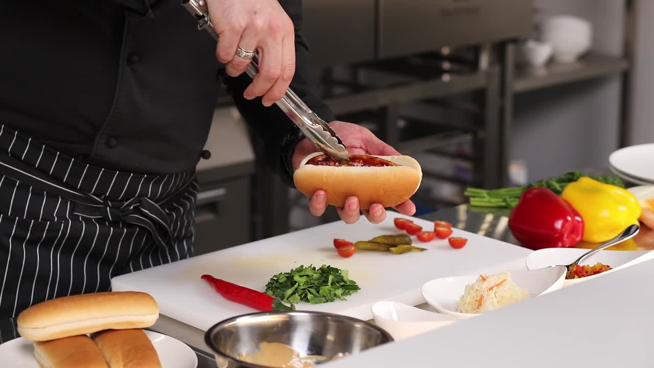 el chef preparando un perrito caliente
