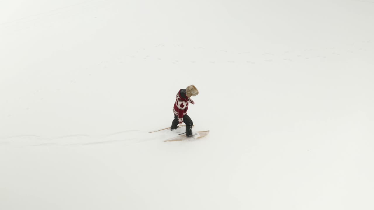 hombre adulto con un gran sombrero de piel, camina y juega con raquetas de nieve tradicionales en un lago congelado con sus perros en el norte de canadá