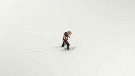 adult man in large fur hat, walks and plays in traditional snowshoes on frozen lake with his pet dogs in northern canada