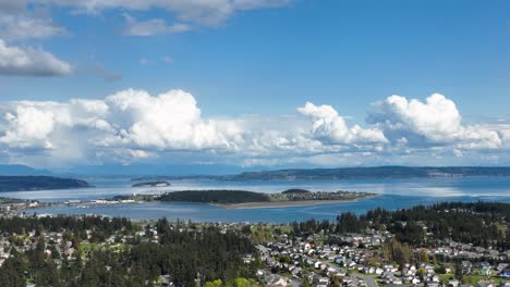 aerial shot of whidbey island's oak harbor surrounded by clouds on a warm summer's day
