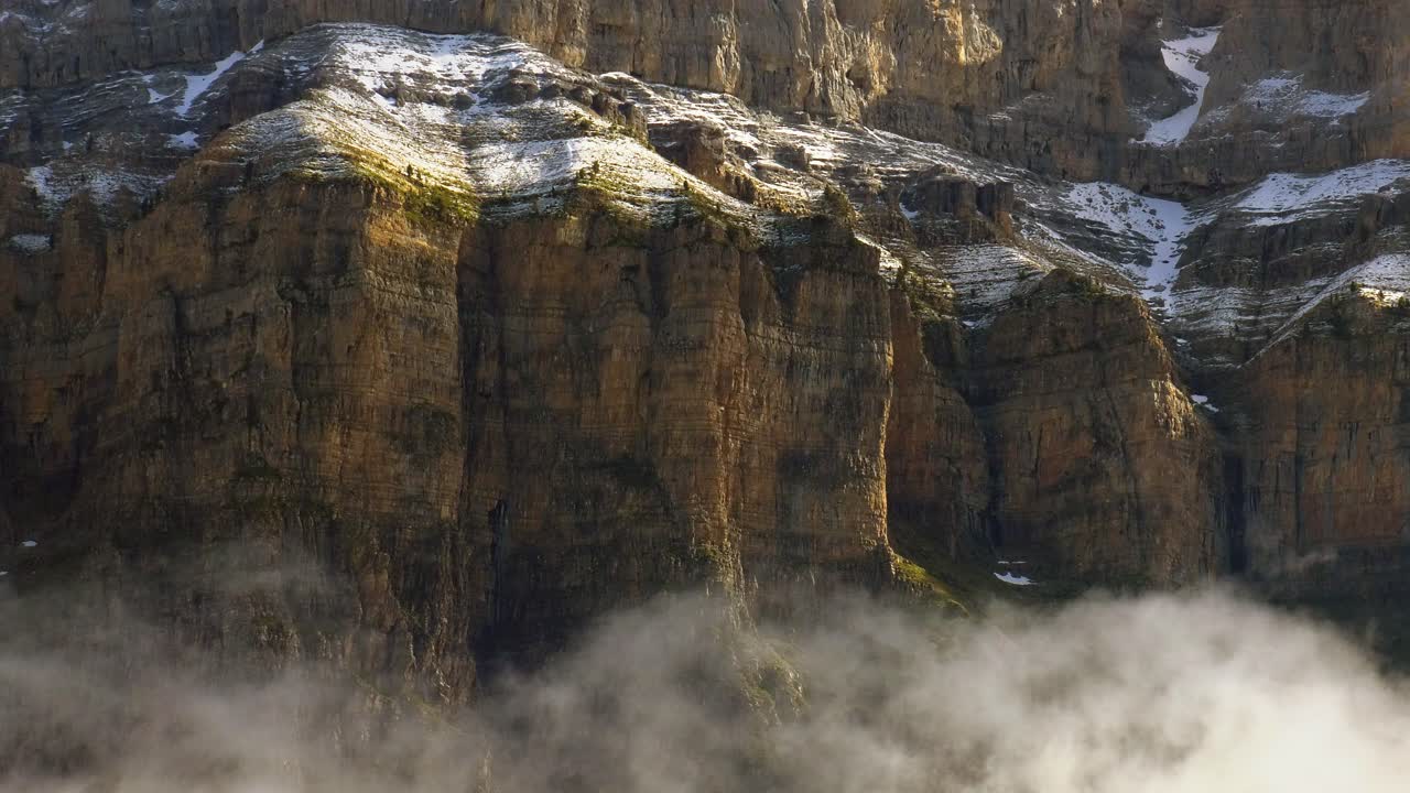 pared de roca de cañón alto espolvoreada con nieve, pirineos