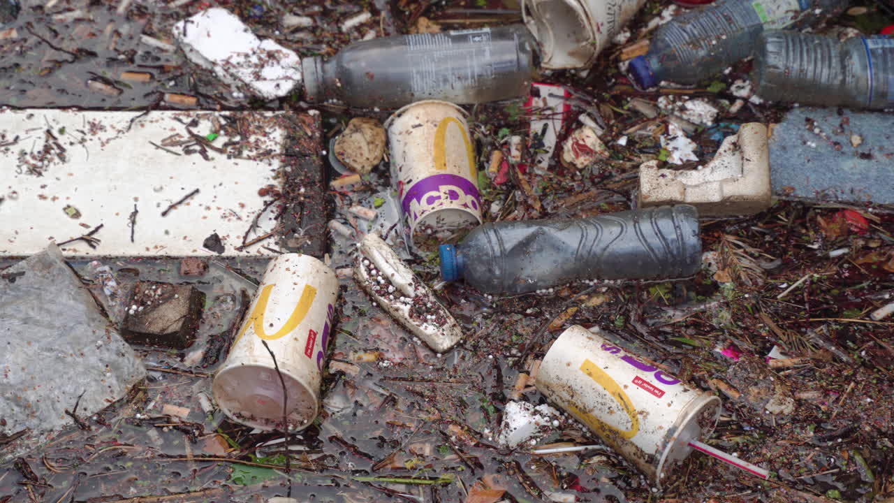 Medium close up shot of trash floating in a canal of Amsterdam, in the Netherlands.