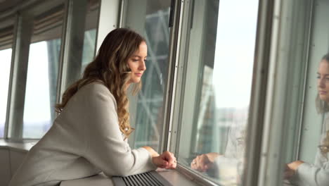 mujer que se queda fuera de la ventana en un rascacielos