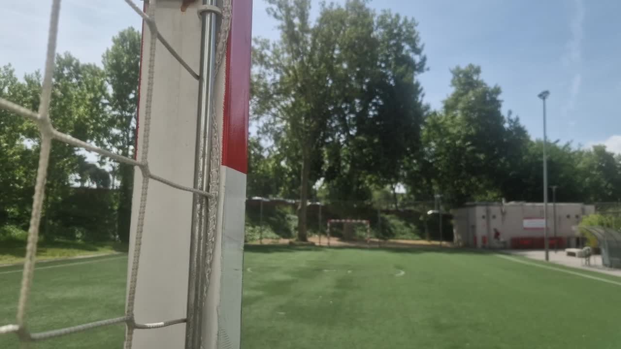 Downward tilting camera movement showing a soccer goal detail on an empty training field