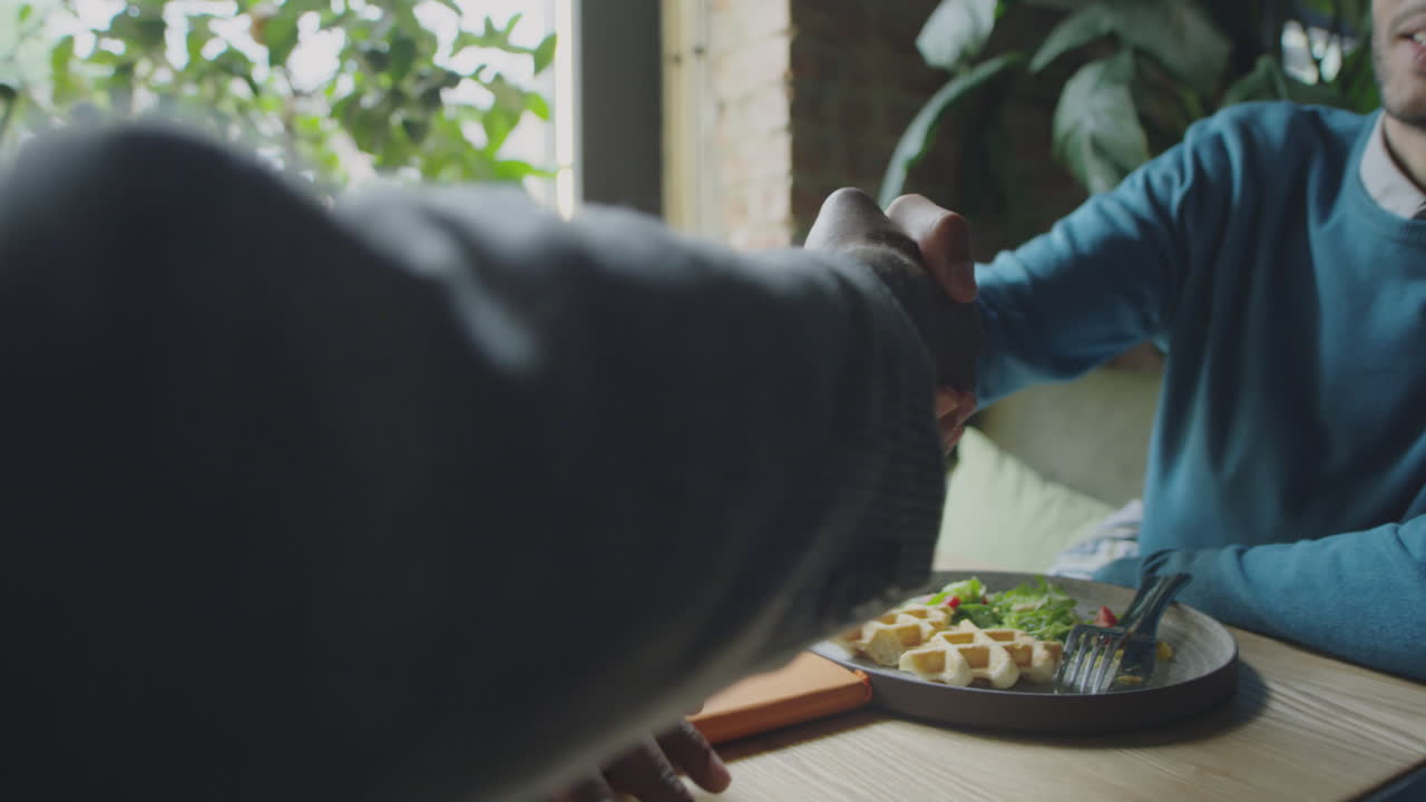 Business Partners Shaking Hands on Lunch in Cafe