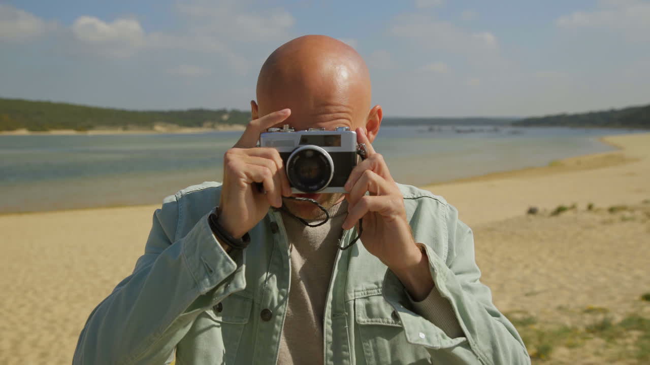 Man taking pictures with camera on beach
