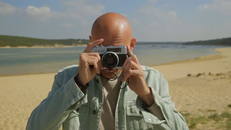 Man-taking-pictures-with-camera-on-beach