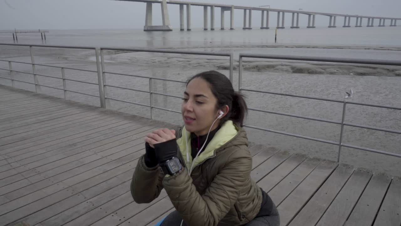 joven morena enfocada con cola de caballo calentándose antes del entrenamiento