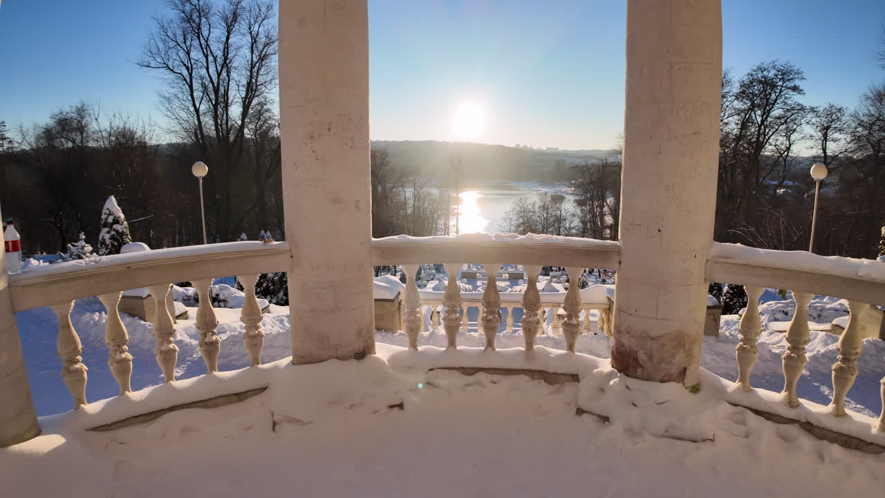 Colonne bianche su un lago ghiacciato con neve bianca in inverno e un sole splendente.