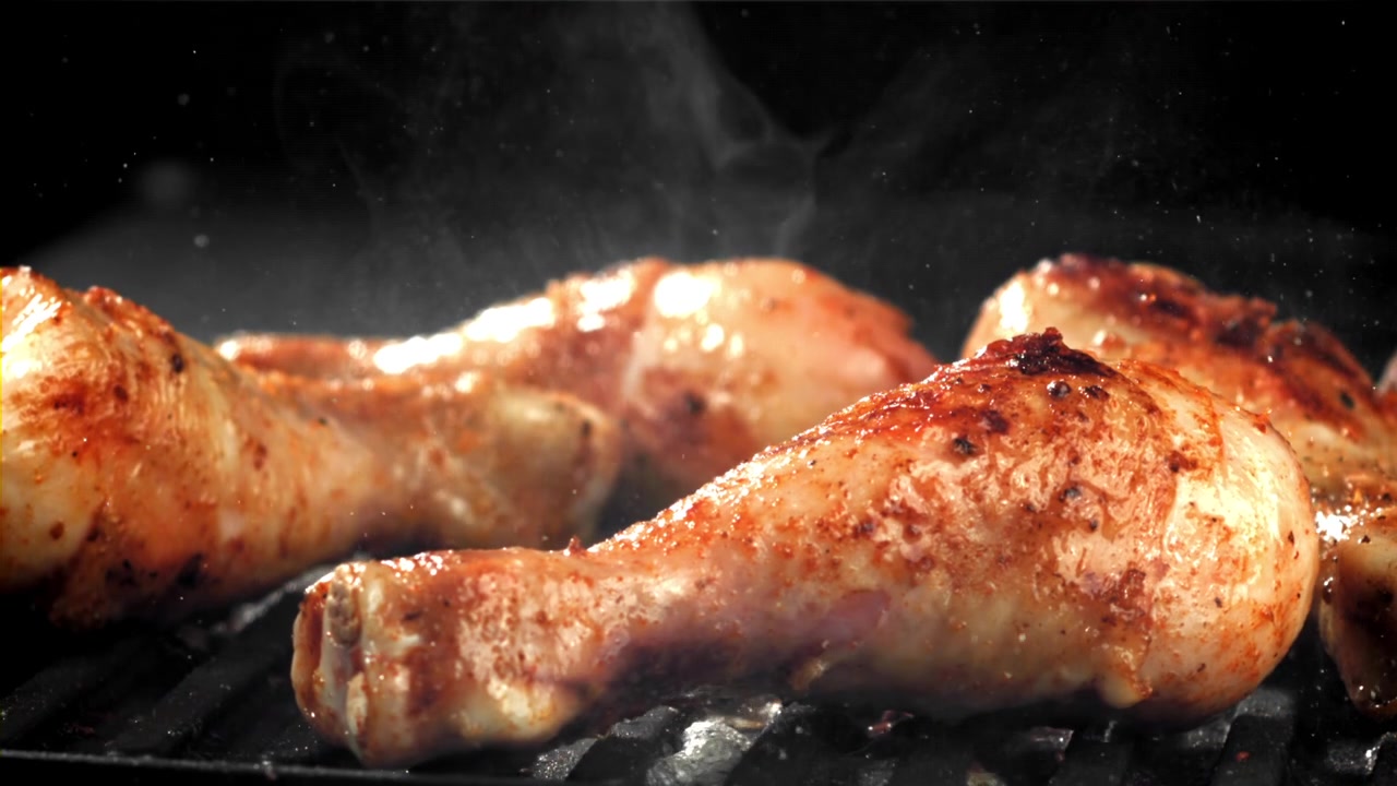 Deliziose cosce di pollo che grigliano su un barbecue caldo
