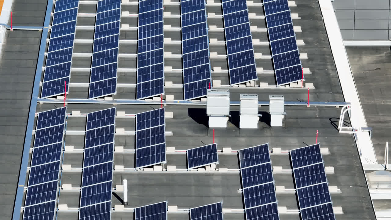 Photovoltaic modules on a building roof, on a summer day - Telezoom drone shot