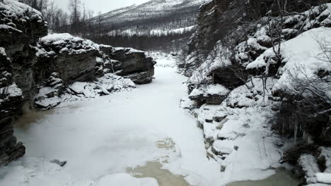 drone flying over frozen river in northern norway