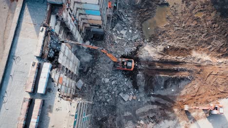 tractor with a special bucket dismantles a collapsed building after a disaster. construction work in the city. shooting from the air