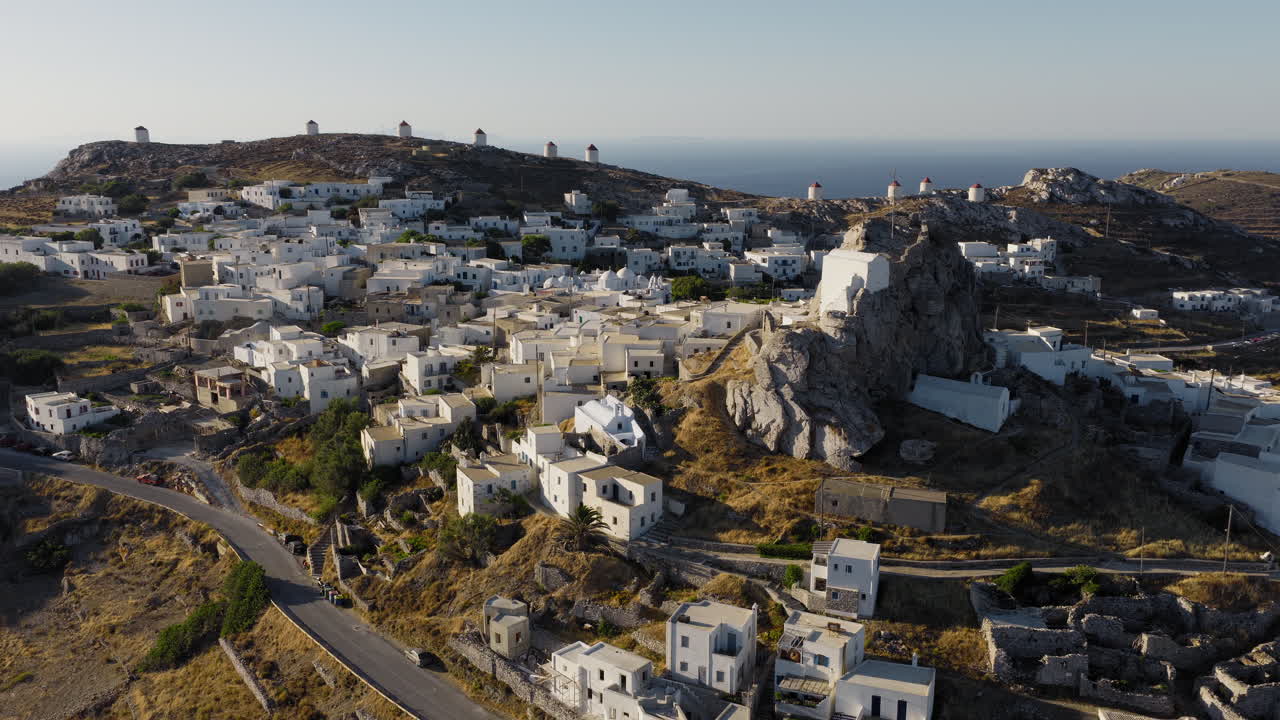 Chora of Amorgos with iconic windmills and Cycladic houses under sunrise light, Greek Cultural tourism